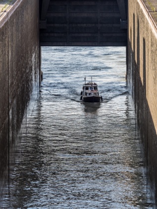 Ein Boot  fährt in die Schleuse ein, bei der Größe der Schleuse sieht es aus wie ein Spielzeug